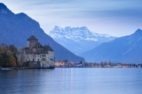 View of the Chillon castle on Lake Geneva and Dents du Midi at sunrise. Veytaux, Montreux, Canton of Vaud, Switzerland.