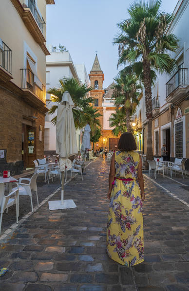 Woman walks along the ancient alley of Barrio de La Vina, Cadiz, Andalusia, Spain