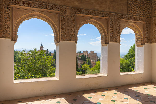 Gardens of Generalife seen from interior room of palace with arabic archways and decorated tiled floor, La Alhambra complex, Granada, Andalusia, Spain