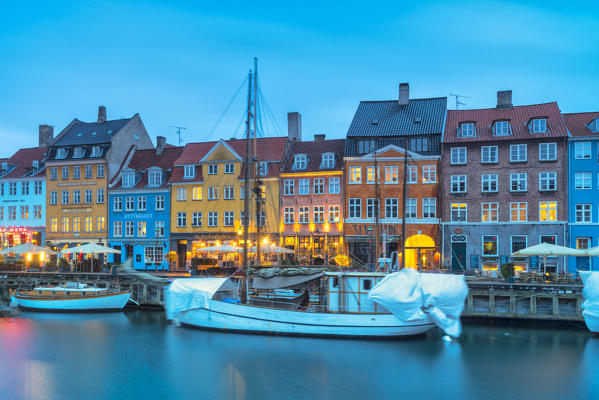 Colorful buildings and old ships along Nyhavn canal at dusk, Copenhagen, Hovedstaden, Denmark