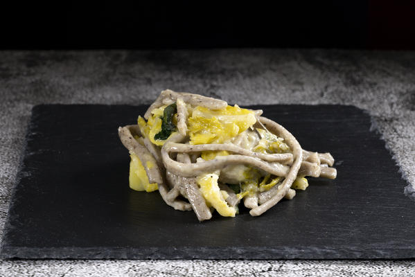 Pizzoccheri on black cutting board, Valtellina, Lombardy, Italy