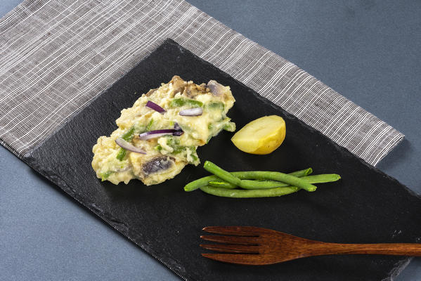 Cooked Taroz with green beans and potatoes as main ingredients on black stone tray, Valtellina, Lombardy, Italy
