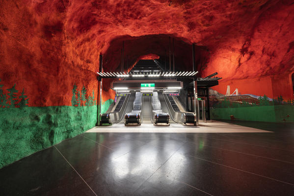 Escalators in Solna Centrum metro station with red and green paintings on ceiling and walls, Stockholm, Sweden