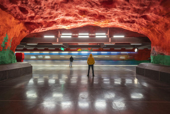 Men looking at artwork and paintings on rocks, Solna Centrum metro station,  Stockholm, Sweden
