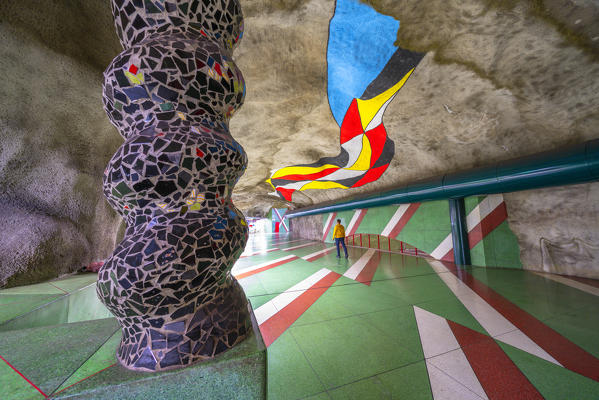 Man in the painted tunnel of the T-Centralen metro station decorated with artwork, Stockholm, Sweden