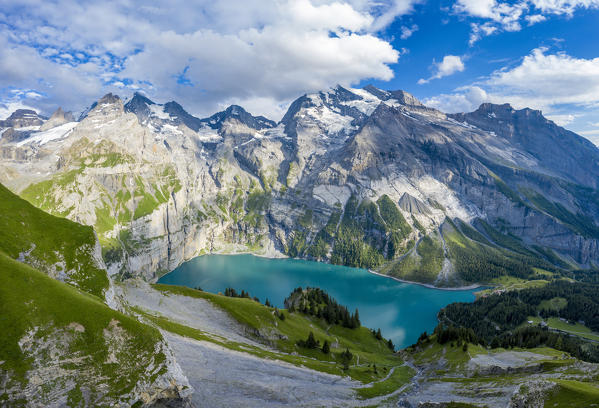 Aerial panoramic of Oeschinensee lake surrounded by woods in summer, Bernese Oberland, Kandersteg, Canton of Bern, Switzerland