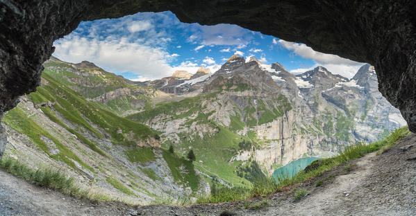 Panoramic of Oeschinensee lake framed by a natural stone arch, Bernese Oberland, Kandersteg, Canton of Bern, Switzerland