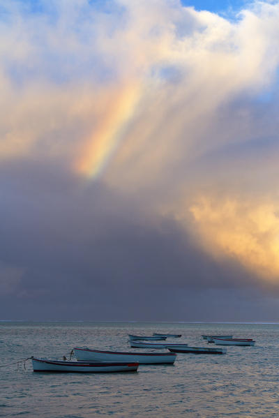 Colorful rainbow in the sky over boats moored in the lagoon, Le Morne Brabant, Black River district, Indian Ocean, Mauritius