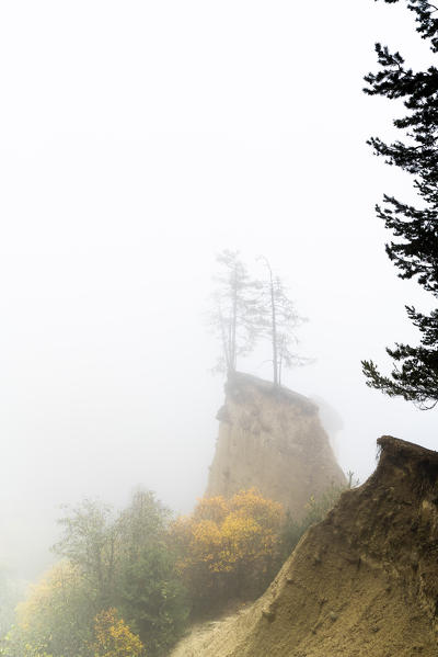 Autumn mist over the Earth Pyramids natural monument in Perca/Percha, province of Bolzano, South Tyrol, Italy