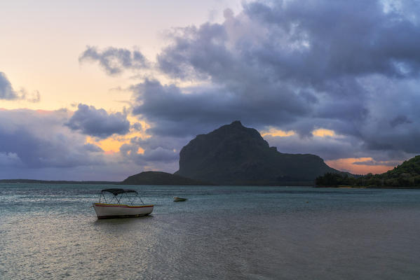 Clouds at dawn over the lone boat in the tropical lagoon, Le Morne Brabant, Black River district, Indian Ocean, Mauritius