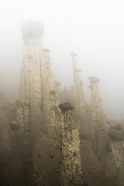 Foggy sky over the surreal Earth Pyramids rock formations, Perca/Percha, province of Bolzano, South Tyrol, Italy