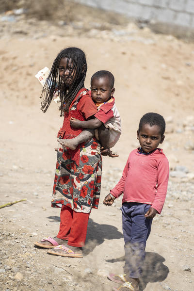 Little girl holding a baby boy on back with brother, Abala, Afar Region, Ethiopia, Africa