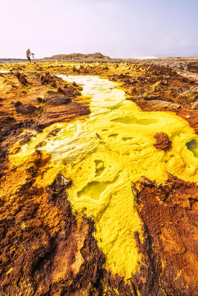 Man photographing the surreal landscape of Dallol volcanic area, Danakil Depression, Afar Region, Ethiopia, Africa