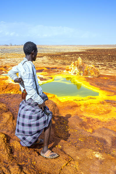 Ethiopian guard standing on top of hot springs, Dallol, Danakil Depression, Afar Region, Ethiopia, Africa