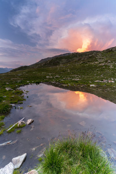 Cloudy sky at  sunset over the small alpine lake, Muottas Muragl, Samedan, canton of Graubunden, Engadine, Switzerland