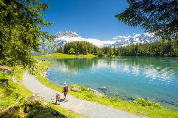 Mother and little child walking on trail on the shores of Lake Arnisee in summer, Canton Uri, Switzerland
