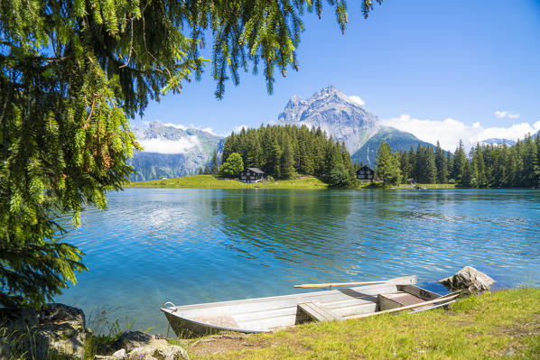 Rowboat moored on shores of Lake Arnisee with Gross Windgallen mountain on background, Canton Uri, Switzerland