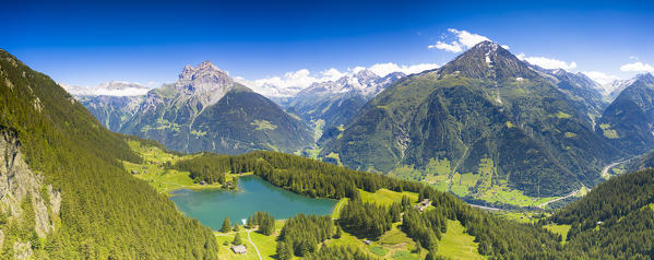 Panoramic of Lake Arnisee and Gross Windgallen mountain surrounded by green forest, Canton Uri, Switzerland