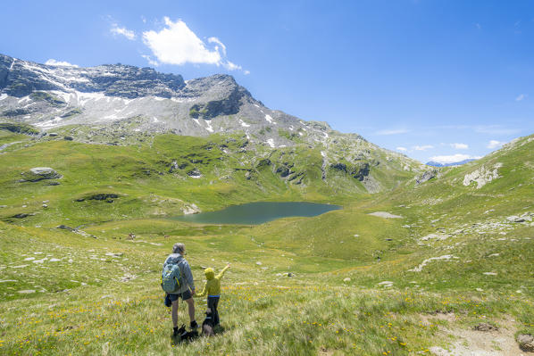 Little boy with grandfather admiring Baldiscio lakes during a hike, Val Febbraro,  Valchiavenna, Vallespluga, Lombardy, Italy (MR)