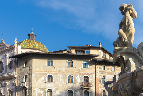 Details of Neptune Fountain statues with the dome of Duomo or San Vigilio Cathedral on background, Trento, Trentino, Italy