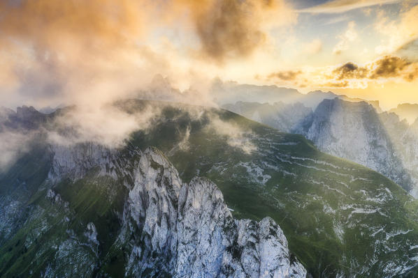 Foggy sunset over the rocky peaks of Santis and Saxer Lucke, aerial view, Appenzell Canton, Alpstein Range, Switzerland
