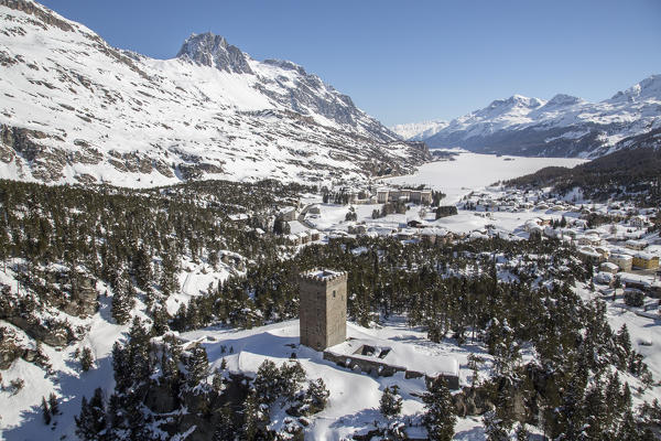 Aerial view of Belvedere tower of maloja with its village on the shores of Sils Lake completely frozen. Maloja Pass. Engadine. Canton of Graubunden. Switzerland.