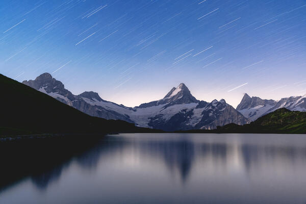 Star trail over Schreckhorn peak reflected in Bachalpsee lake, Grindelwald, Bernese Oberland, Bern Canton, Switzerland