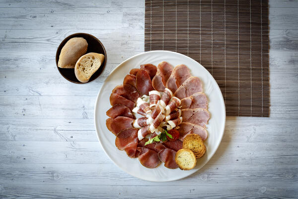 Cold cuts appetizer of beef, duck, goose in white dish from above