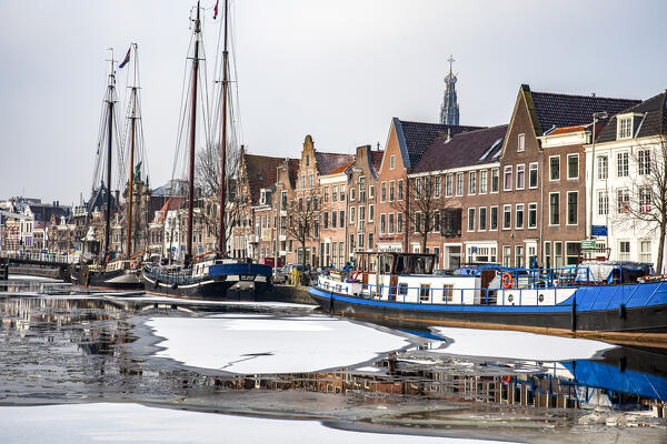 Traditional houses and boats along the Spaarne river canal in  Haarlem old town, Amsterdam, North Holland, The Netherlands