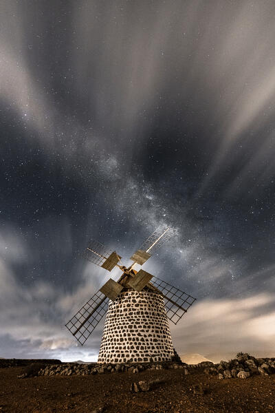 Clouds in the starry sky above the stone windmill, La Oliva, Fuerteventura, Canary Islands, Spain