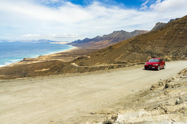 Car traveling on desert road to Cofete Beach, Jandia natural park, Fuerteventura, Canary Islands, Spain