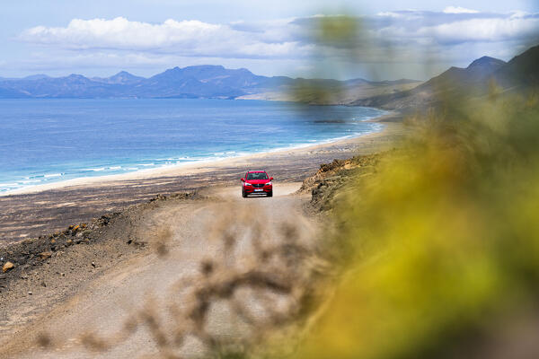 Car traveling on desert road to Cofete Beach, Jandia natural park, Fuerteventura, Canary Islands, Spain