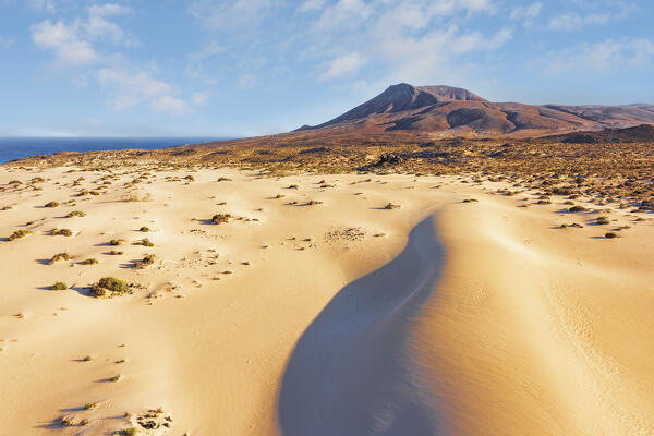 clouds over red volcanic mountains and sand dunes in  Corralejo Natural Park, Fuerteventura, Canary Islands, Spain