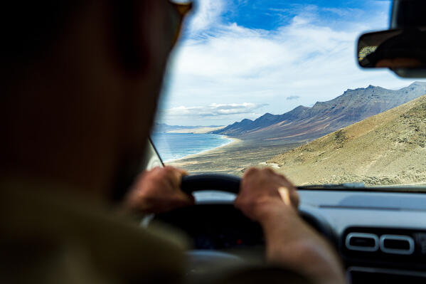 Personal perspective of man driving to Cofete Beach, Jandia natural park, Fuerteventura, Canary Islands, Spain