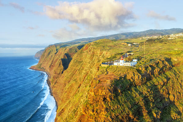 Sunset over Ponta do Pargo lighthouse on top of cliffs, aerial view, Calheta, Madeira, Portugal