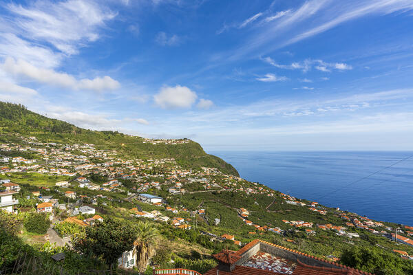 Arco da Calheta village in the lush vegetation on hills by the ocean, Madeira island, Portugal