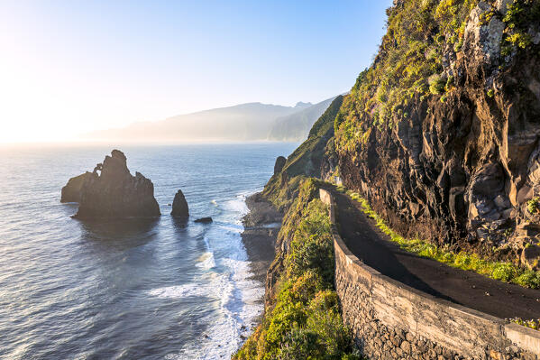 Old coastal road with Ilheus da Rib and Ribeira da Janela sea stack rocks on background, Porto Moniz, Madeira, Portugal