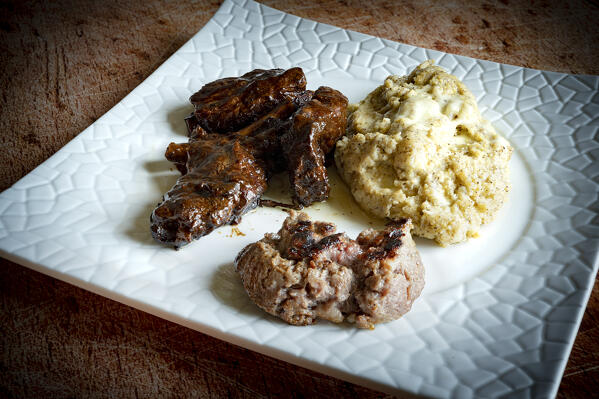 Close up of typical polenta taragna with sausage and pork ribs, Valtellina, Lombardy, Italy