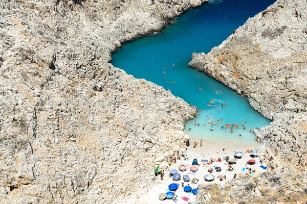 People swimming in the crystal sea and tanning on the idyllic Seitan Limania sand beach, Chania, Crete, Greece