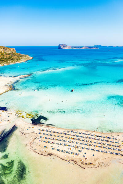 Aerial view of sunshades and lounge chairs on the equipped beach between sea and lagoon, Balos, Crete, Greece
