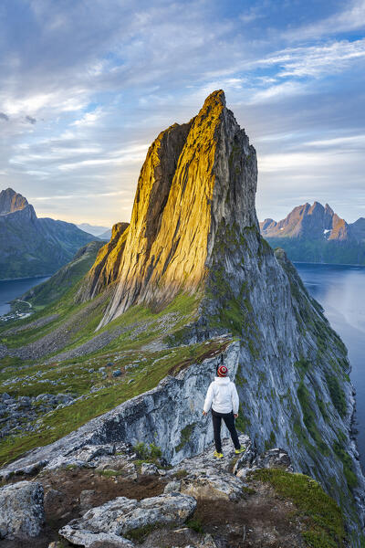 Person contemplating sunrise over Segla peak standing on mountain, Senja island, Troms county, Norway