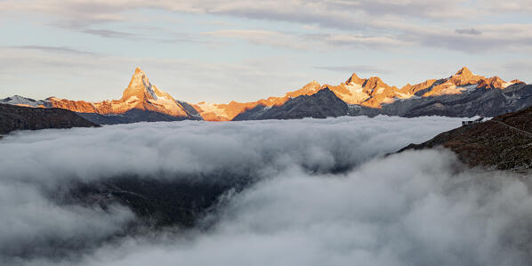 Aerial view of Matterhorn, Dent Blanche, Zinalrothorn peaks and Stellisee in fog at dawn, Zermatt, Valais canton, Switzerland