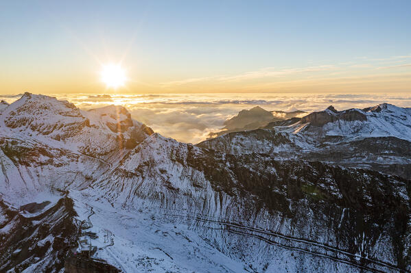 Aerial view of Piz Gloria covered with snow in a sea of clouds at sunset, Murren Birg, Jungfrau Region, Bern canton, Switzerland
