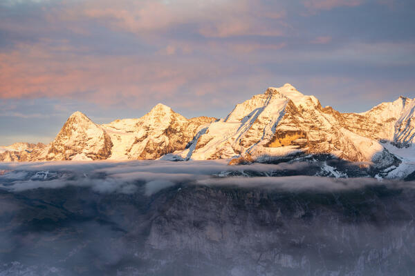 Snowy Eiger, Monch and Jungfrau mountains emerging from fog at sunset, Murren Birg, Jungfrau Region, Bern canton, Switzerland