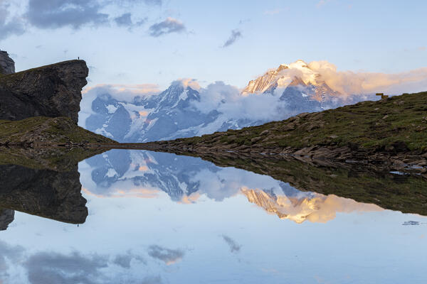 Majestic peaks of Eiger, Monch and Jungfrau reflected in Grauseeli lake at sunset, Murren Birg, Bern canton, Switzerland