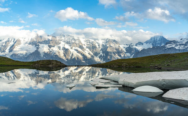 Mountain peaks reflected in the pristine Grauseeli lake at sunset, Murren Birg, Jungfrau Region, Bern canton, Switzerland