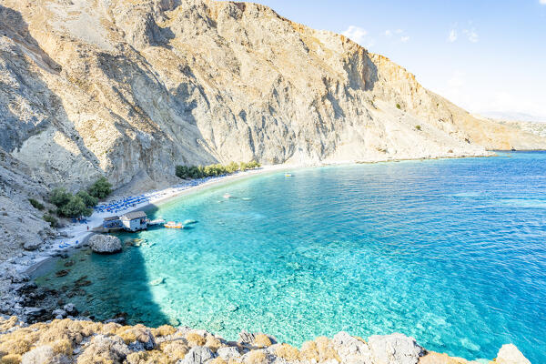 High angle view of the sandy beach Glyka Nera in between mountains and crystal sea, Hora Sfakion, Crete island, Greece