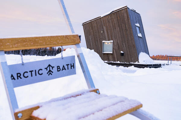 Wooden cabin room of the Arctic bath hotel floating on the frozen river Lule covered with snow, Harads, Lapland, Sweden
