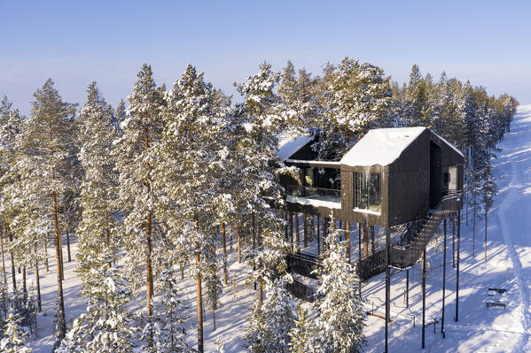 Aerial view of suspended luxury wood suite built among treetops in the snow, Tree hotel, Harads, Lapland, Sweden