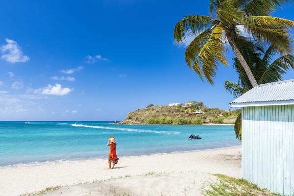 Woman admiring the crystal sea standing on a tropical beach, Antigua, Leeward Islands, Caribbean, West Indies